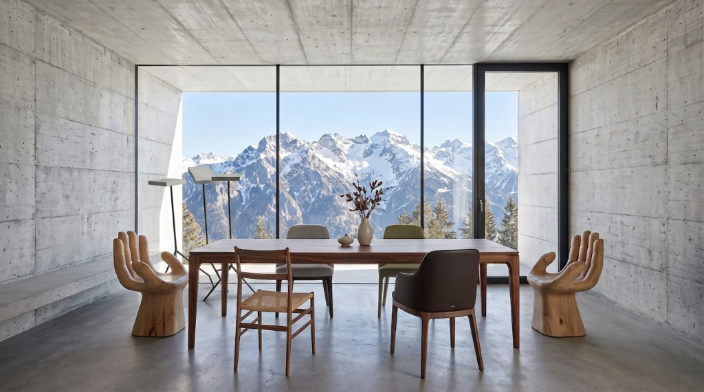 Showroom with dining table, designer chairs and mountain panorama