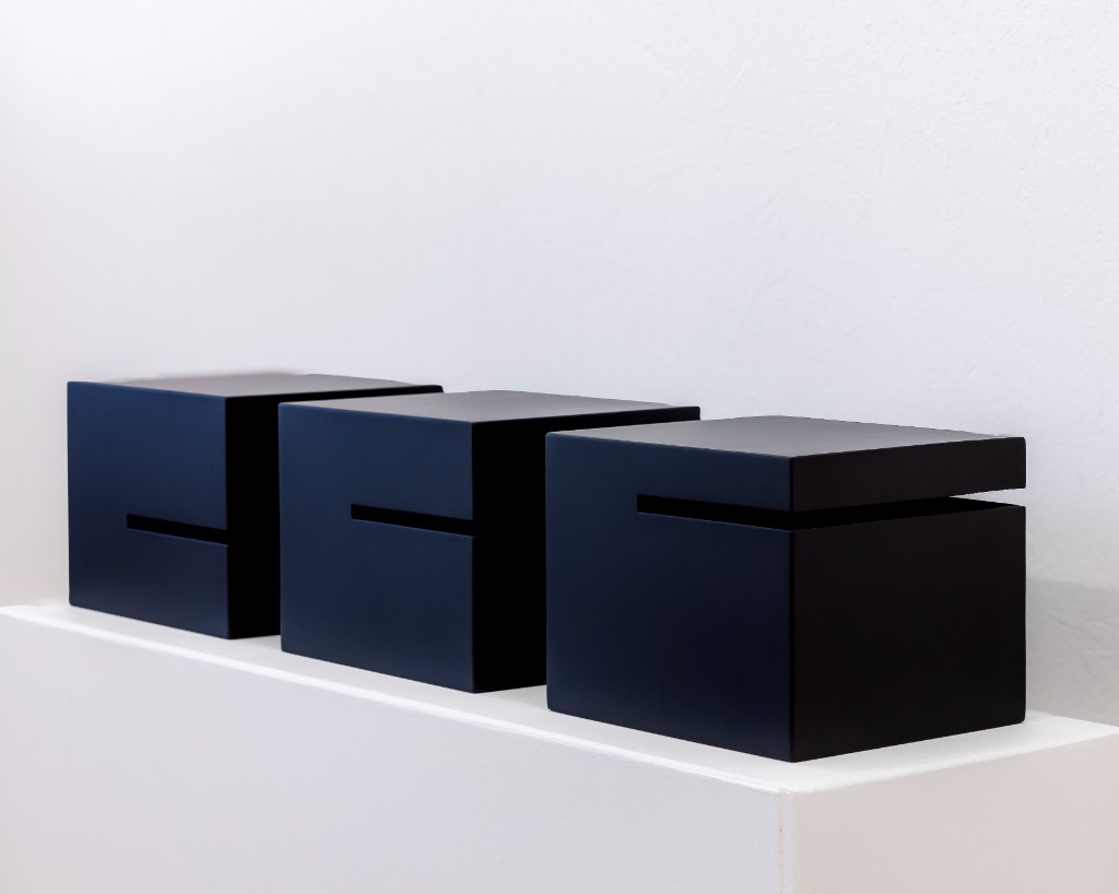 Three black cubes with slit openings